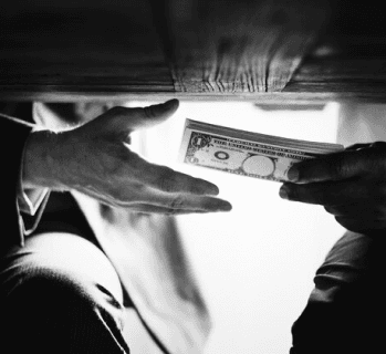 Money being passed under a table